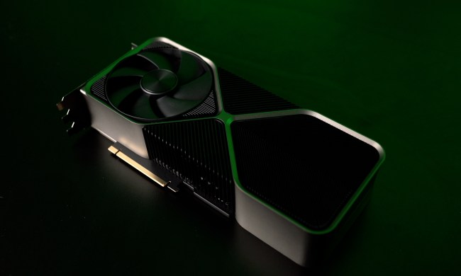 The RTX 4090 graphics card sitting on a table with a dark green background.